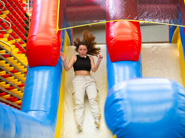 A person slides down a bouncy castle slide