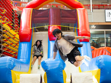 Two people climb off a bouncy castle slide