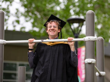 A graduate does a chin-up