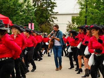 Country music artist Travis Dolter and the Chinook Country Line Dancers at the President's Stampede Barbecue. 