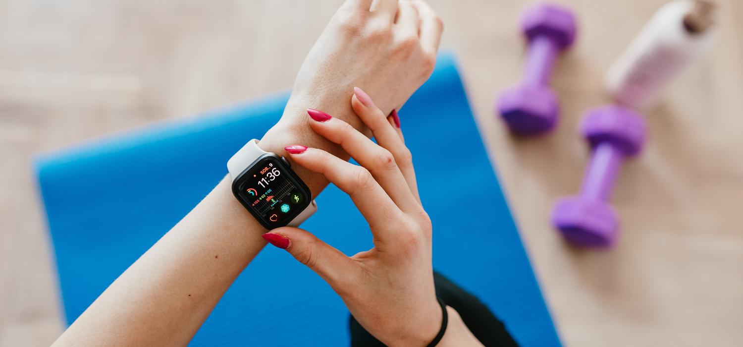 Closeup of hands using a smartwatch to check fitness