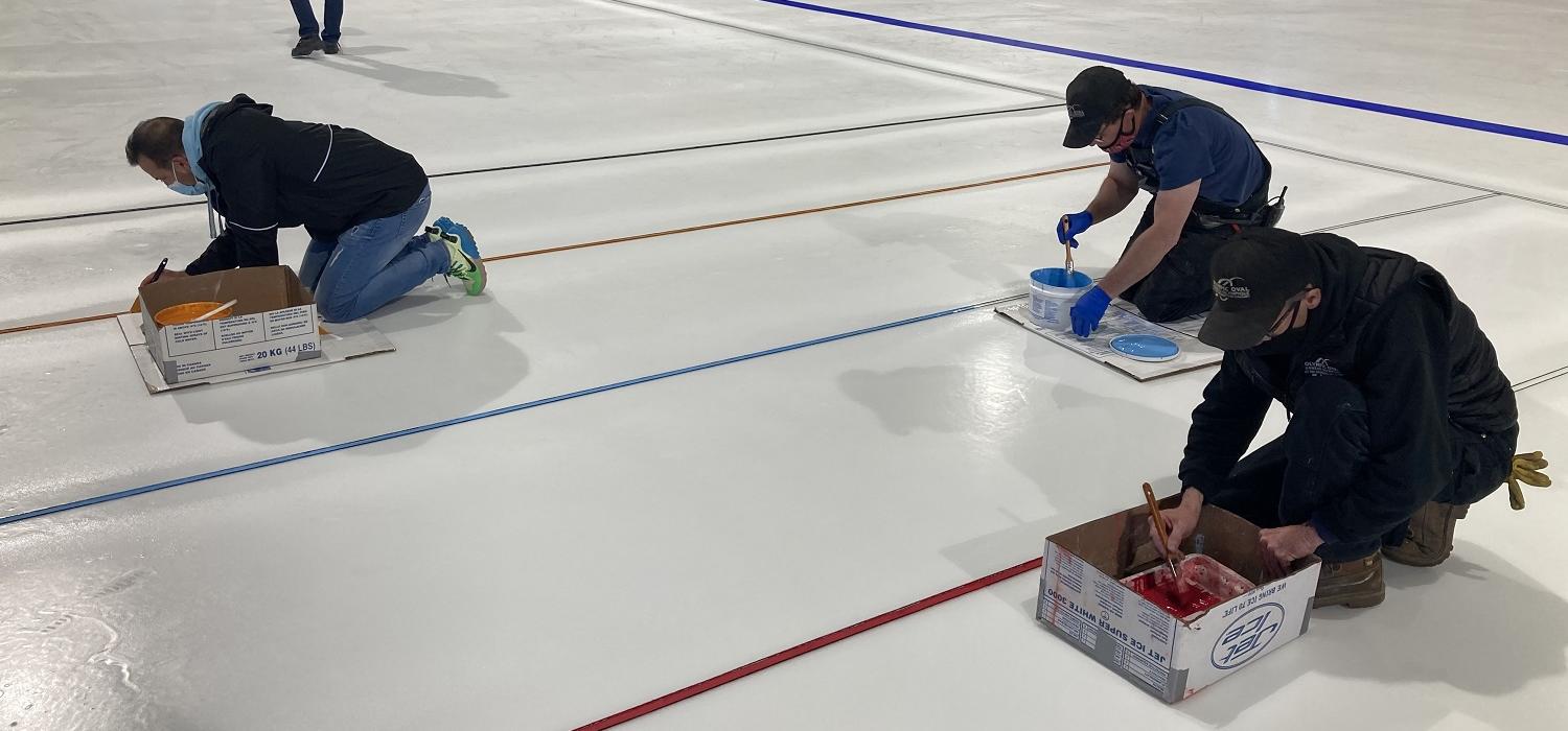 Olympic Oval operations team painting lines on the ice