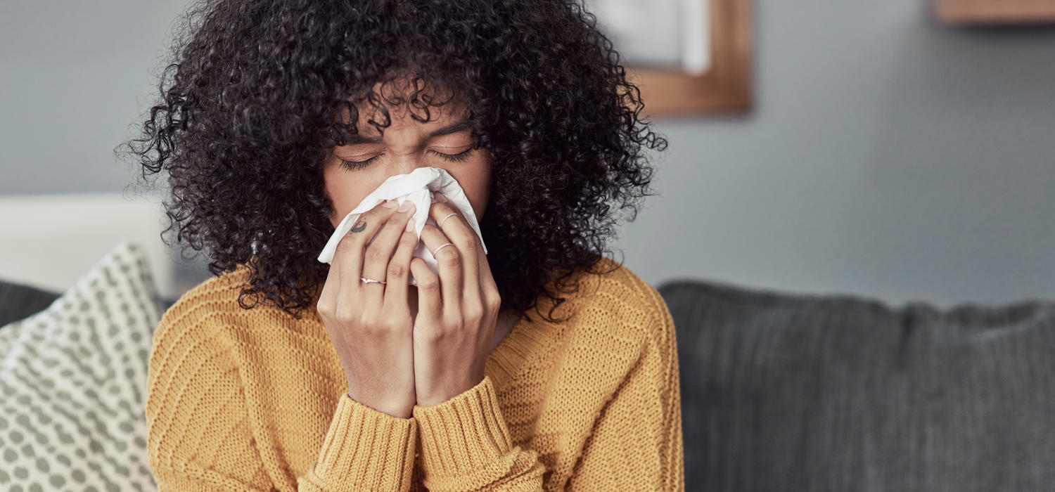 Young woman blowing her nose