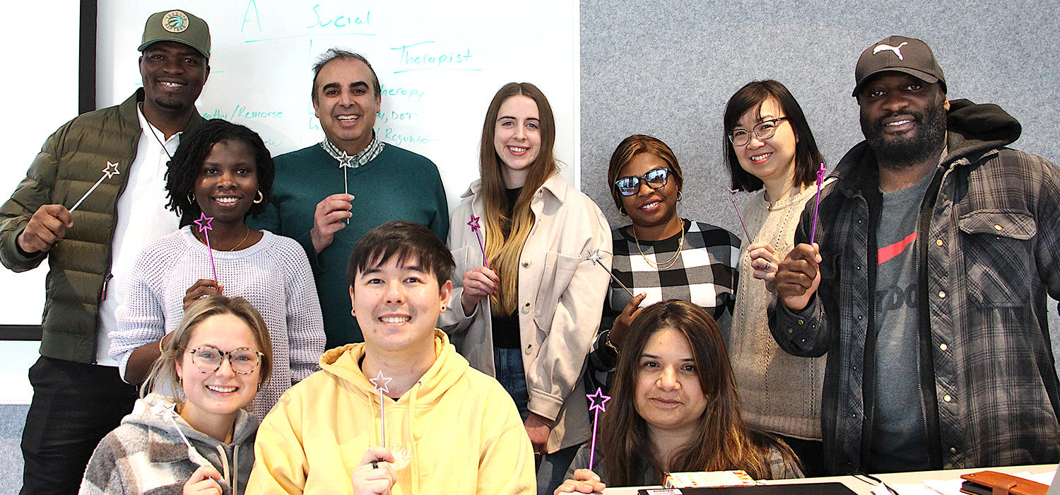 Lateef Habib is surrounded by his students; they are all holding up plastic magic wands.