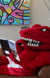 Rex sitting on a couch, reading a book