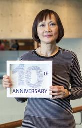 Grace Li with her personalized word cloud that she received two years ago to mark 10 years of service at the university. The word cloud was created by Tracey Helten. University of Calgary photo