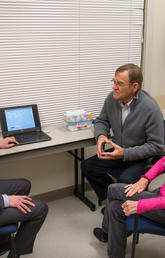 Matthew James, left, talks with patient Sam Hannon, who underwent two angioplasty procedures after having a heart attack, and his wife Myrna Hannon. 