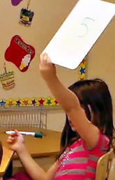 Student with whiteboard in classroom