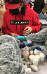 A child practices bandaging an animal on a stuffed toy.