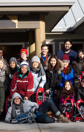 Students stand with snowshoes in hand