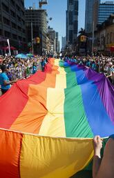 Volunteers carry a large rainbow flag during the 2019 Pride Parade in Toronto. 