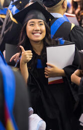 Graduand gives thumbs up at convocation