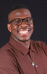 A closeup headshot of a man wearing glasses