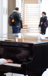 A student playing piano with headphones