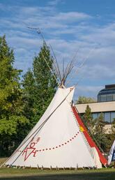 One of the UCalgary tipis in front of MacEwan Hall on a sunny day.