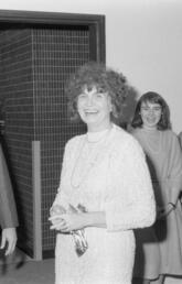 A black and white photo of two men and one woman in conversation