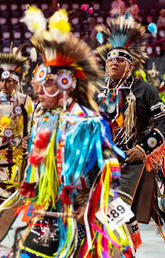 Indigenous people at a powwow dance gathering.