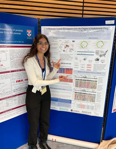 Noelle Thundathil stands beside her poster at the 2023 British Society of Parasitology Spring Meeting.