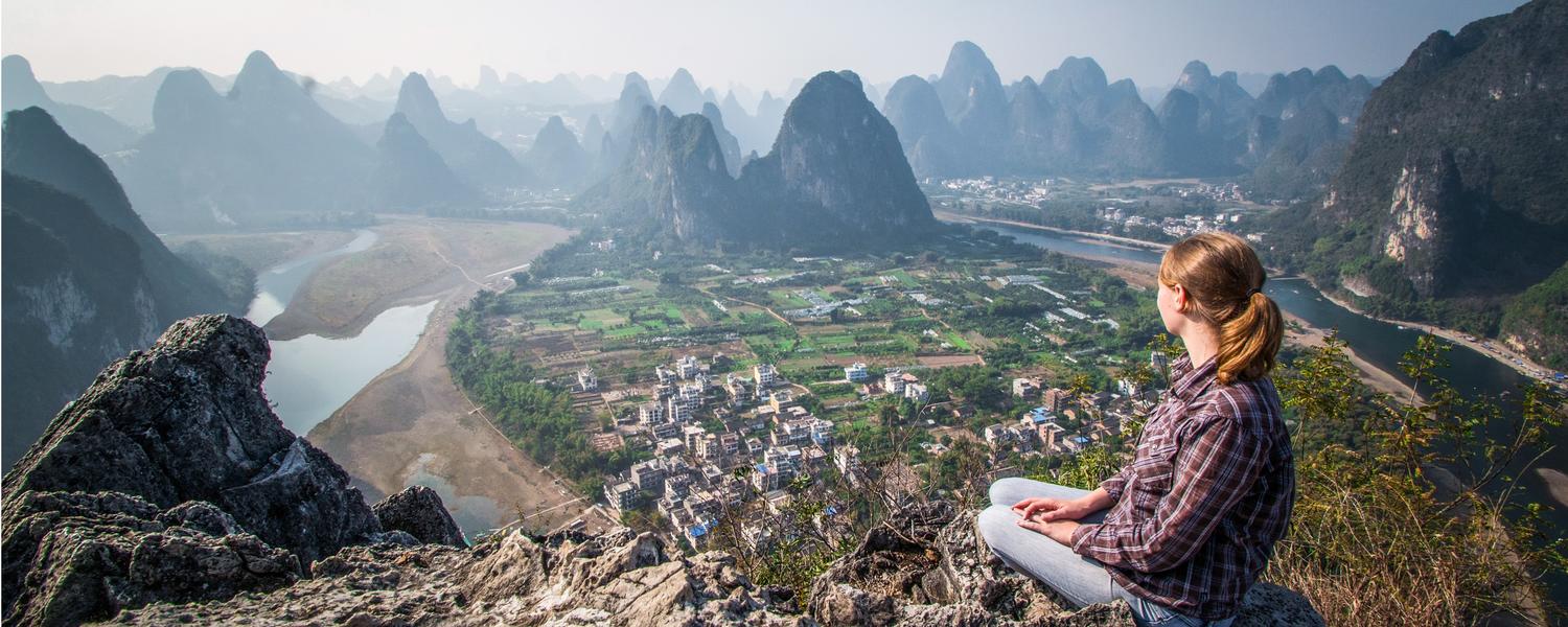 Image of student on a hill overlooking a fishing village in Vietnam