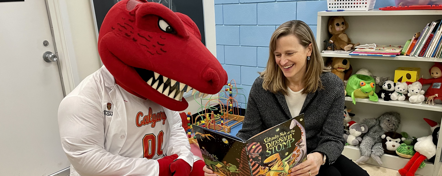 Dr. Penny Pexman and Rex O'Saurus read books in the lab