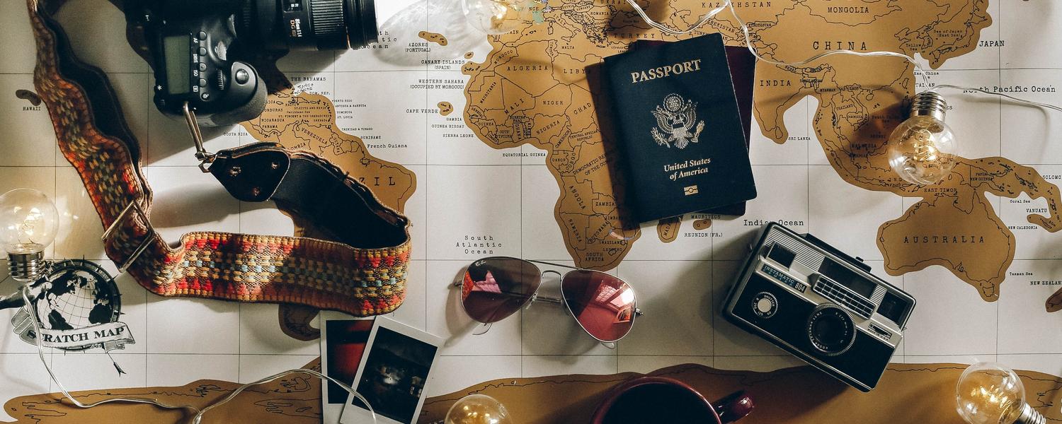 Map with travel knick-knacks, Photo by Charlotte Noelle on Unsplash