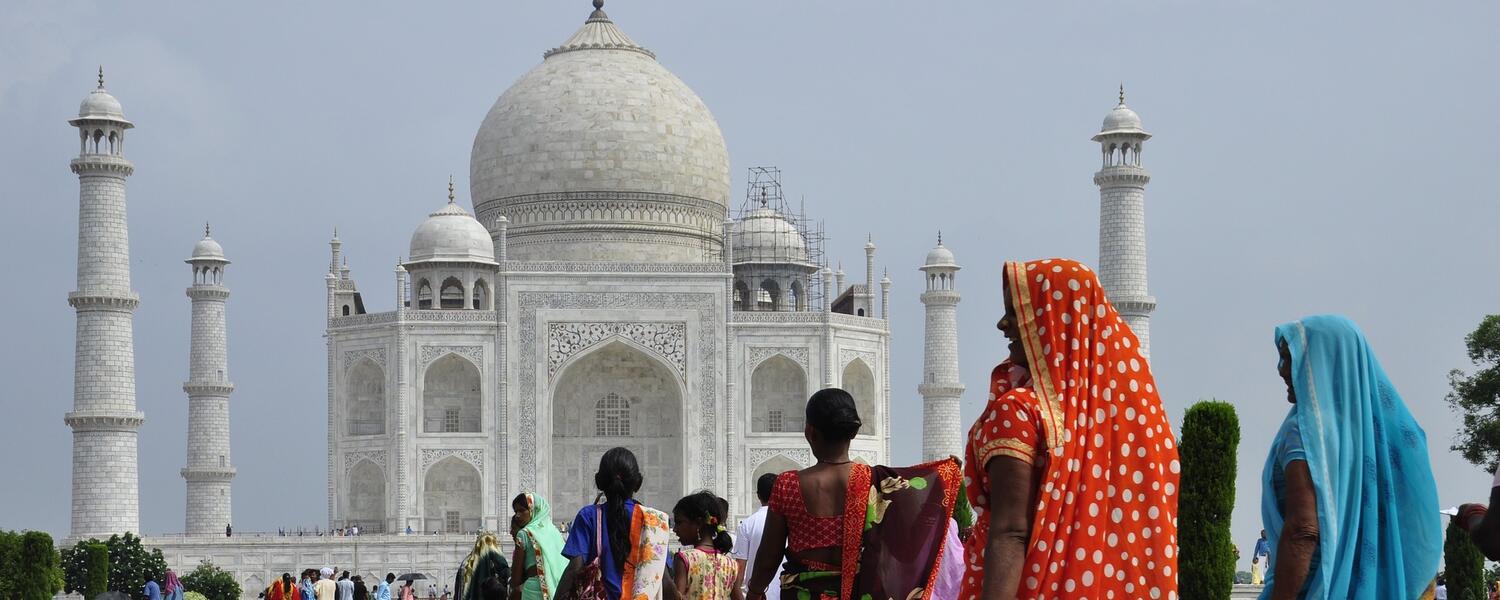 women in head scarves walking towards the Taj Mahal