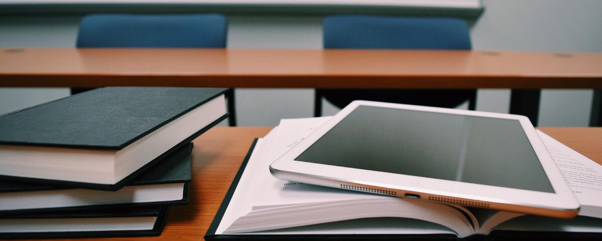 silver tablet on books