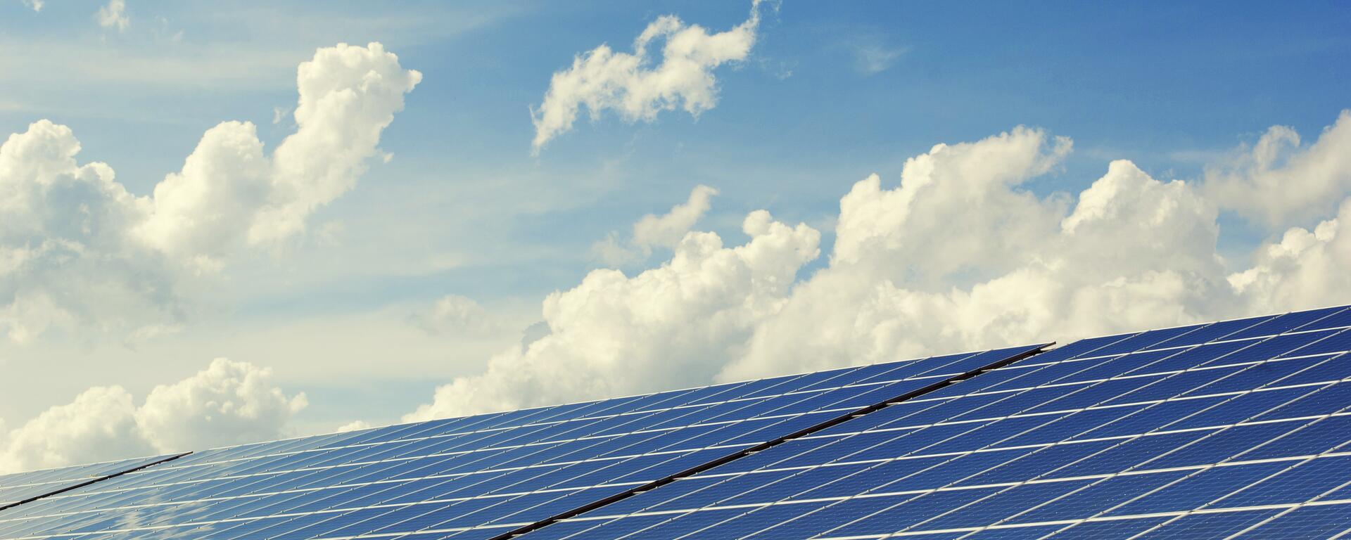 solar panels visible against clear blue sky with white clouds