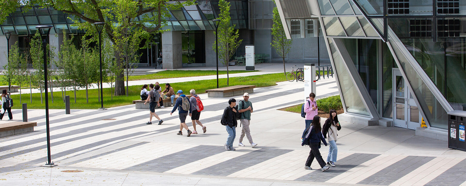 Photo of people on campus in front of the Hunter Student Commons in the spring time.