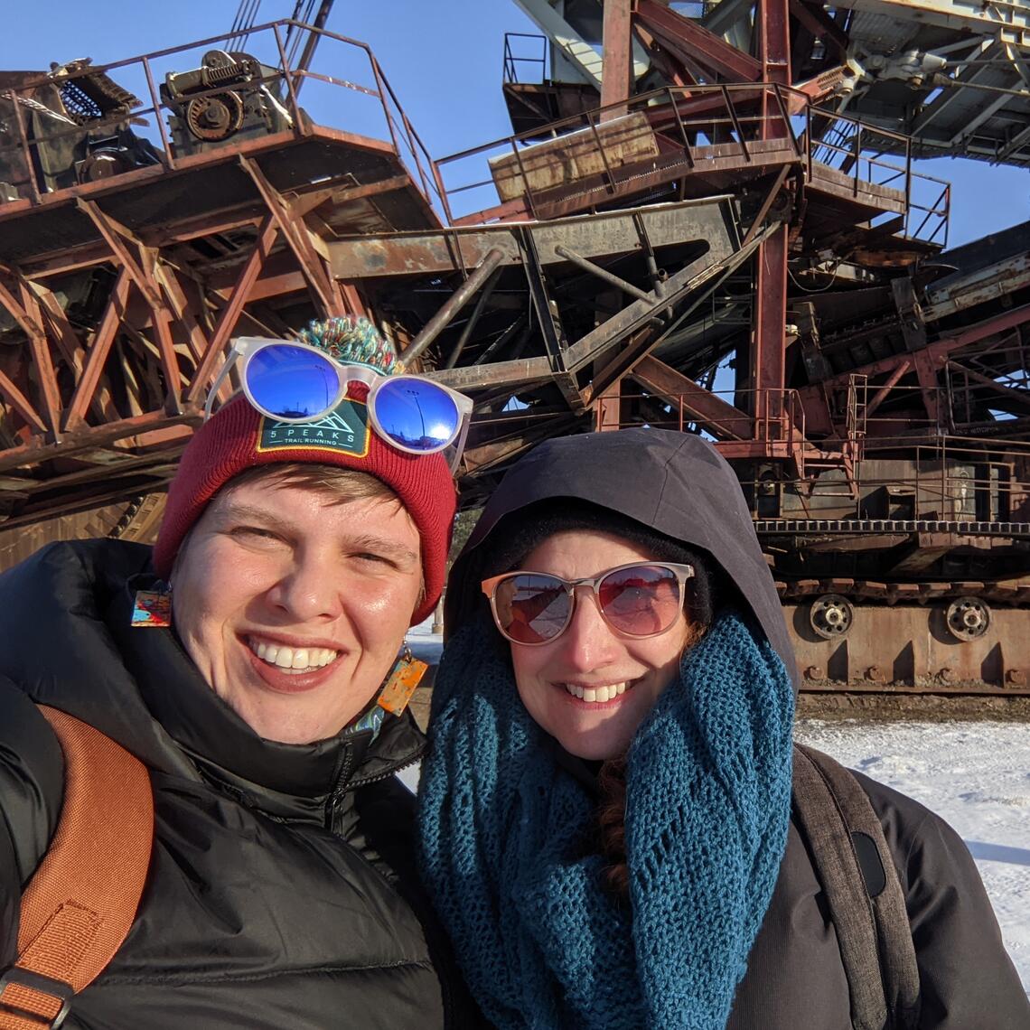 People in front of an excavator