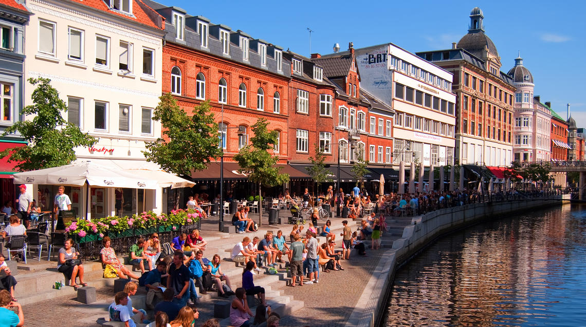 Image of pedestrians sitting alongside Aarhus canal Image of pedestrians sitting alongside Aarhus canal