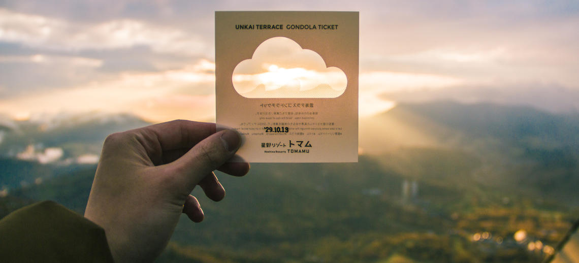 Image of student holding up a gondola ticket on Mt Tomamu in Japan