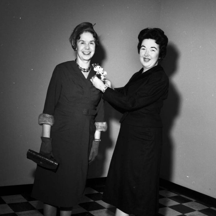 Image of Ethel M. King, advisor to women students and assistant professor of education, right, arranging a gift corsage for Phyllis Ford, wife of Chief Justice Clinton J. Ford, before the ceremonies to open the Arts and Education building. Image of Ethel M. King, advisor to women students and assistant professor of education, right, arranging a gift corsage for Phyllis Ford, wife of Chief Justice Clinton J. Ford, before the ceremonies to open the Arts and Education building.