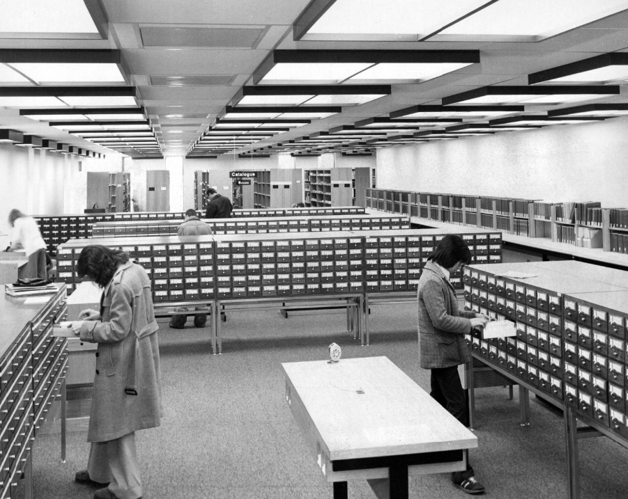 Image of students using the University of Calgary library card catalogue cabinets.