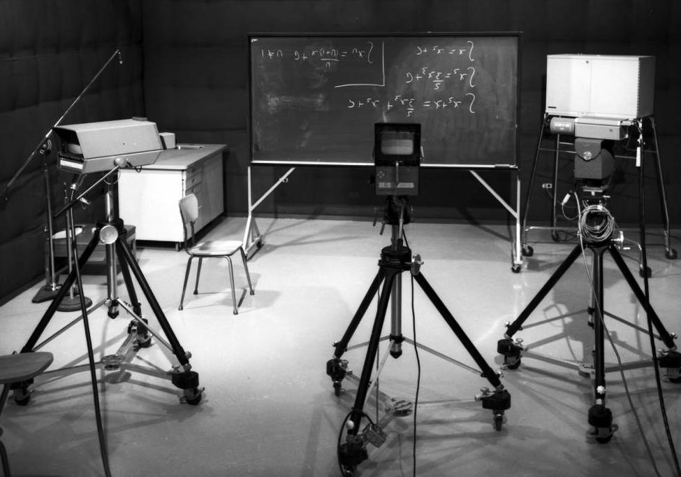 A University of Calgary TV studio with video cameras and a blackboard with four equations written on it. A University of Calgary TV studio with video cameras and a blackboard with four equations written on it.