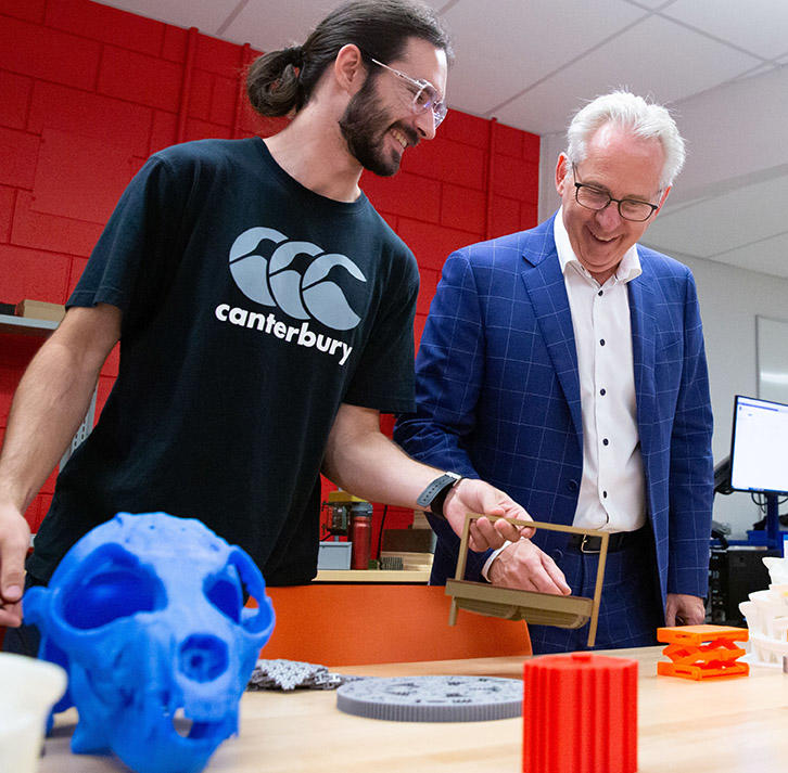 UCalgary President Ed McCauley with a student discussing the student's research.