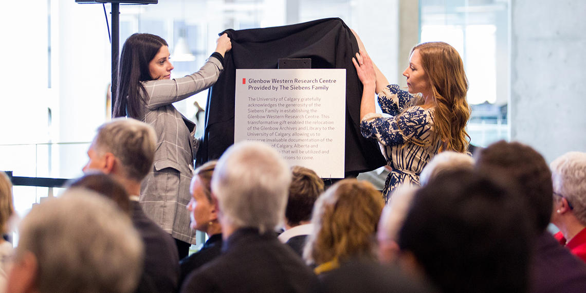 Plaque announcing Glenbow museum donation is unveiled in front of a crowd of people