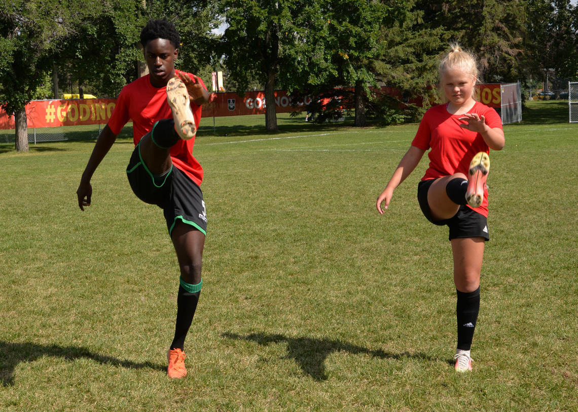 Soccer athletes performing high kicks