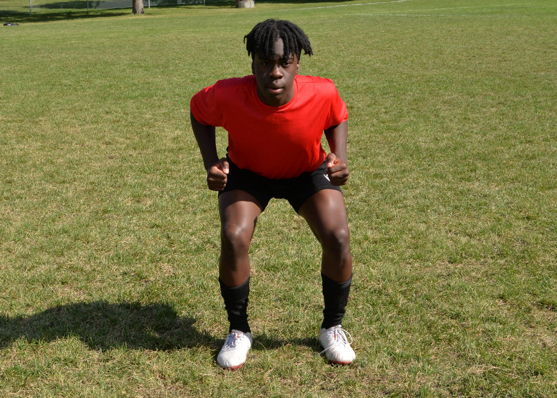 Soccer athlete performing squat with calf raise