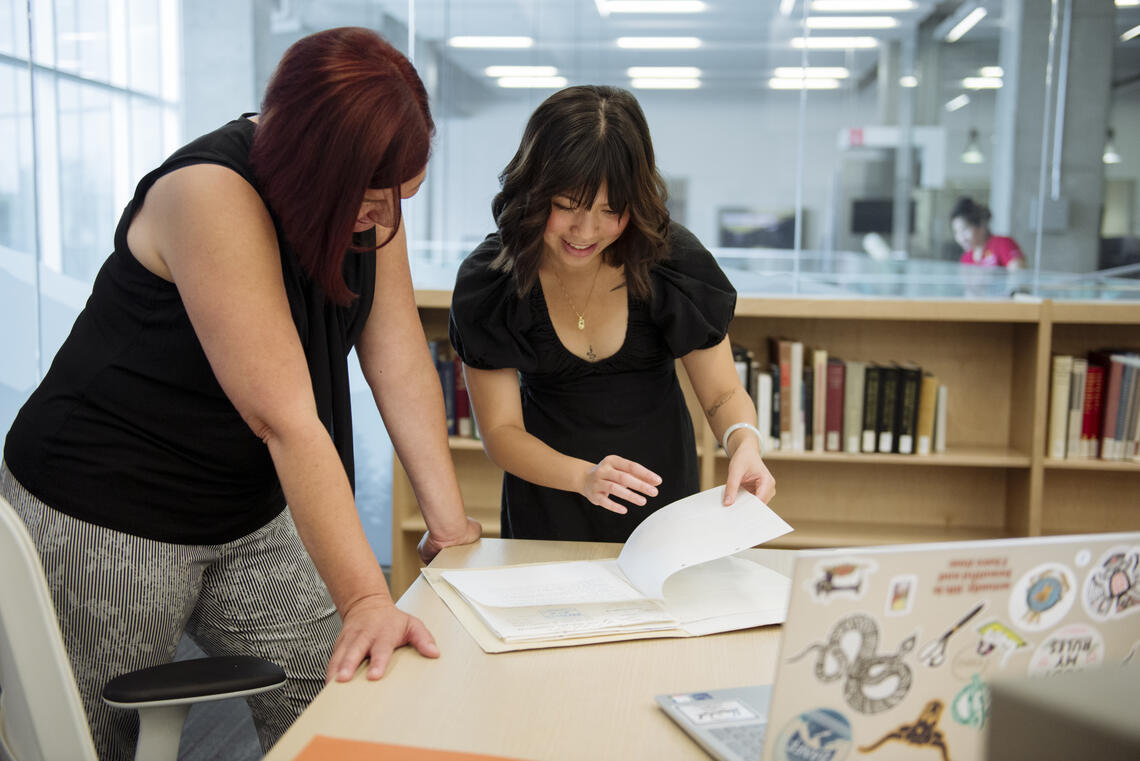 Katie Qin and her supervisor Nancy Janovicek look over documents in the Glenbow Western Research Centre.