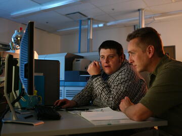 Mike Wieser and Chris Petten sitting at a computer