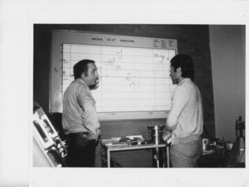 Roy and graduate student standing at a chart of sulphur abundances