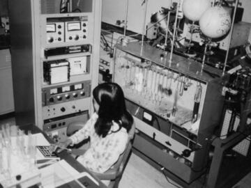 Nenita Lozano with computer and mass spectrometer