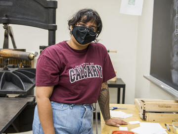 Anisha Baproda standing beside her work station in the Book Arts Lab.