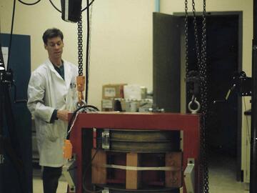 Man with a large red magnet on a crane.
