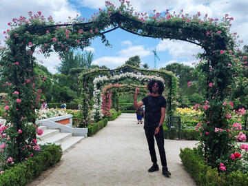 A young man standing under a floral arch in Spain.