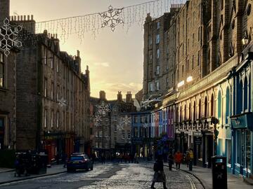 Looking down a street with a dusting of snow and star-shaped lights hanging overhead