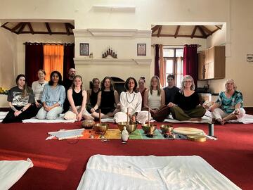 Students sitting on the floor resting after a meditation session