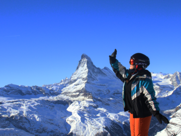 Student posing in ski gear on a mountain top