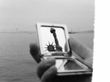 A pocket mirror with a reflection of the Statue of Liberty